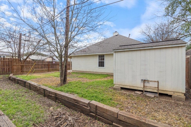 view of yard featuring an outbuilding, a storage shed, and fence