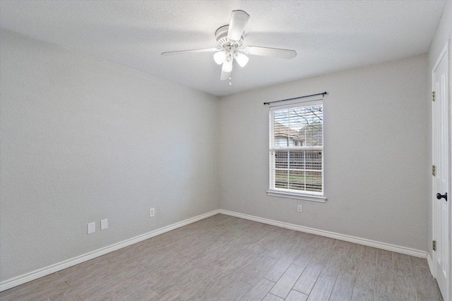 unfurnished room with a textured ceiling, baseboards, a ceiling fan, and wood finished floors