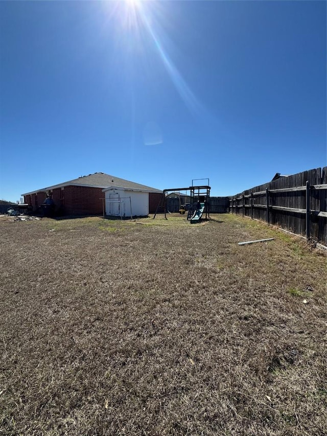 view of yard featuring a playground and fence