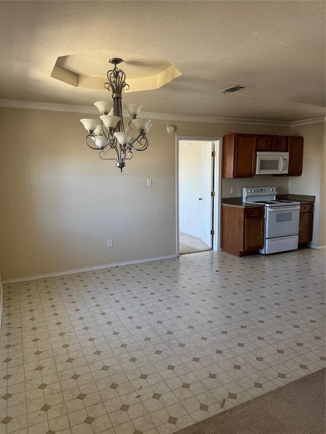 kitchen featuring crown molding, a tray ceiling, a notable chandelier, white appliances, and a textured ceiling