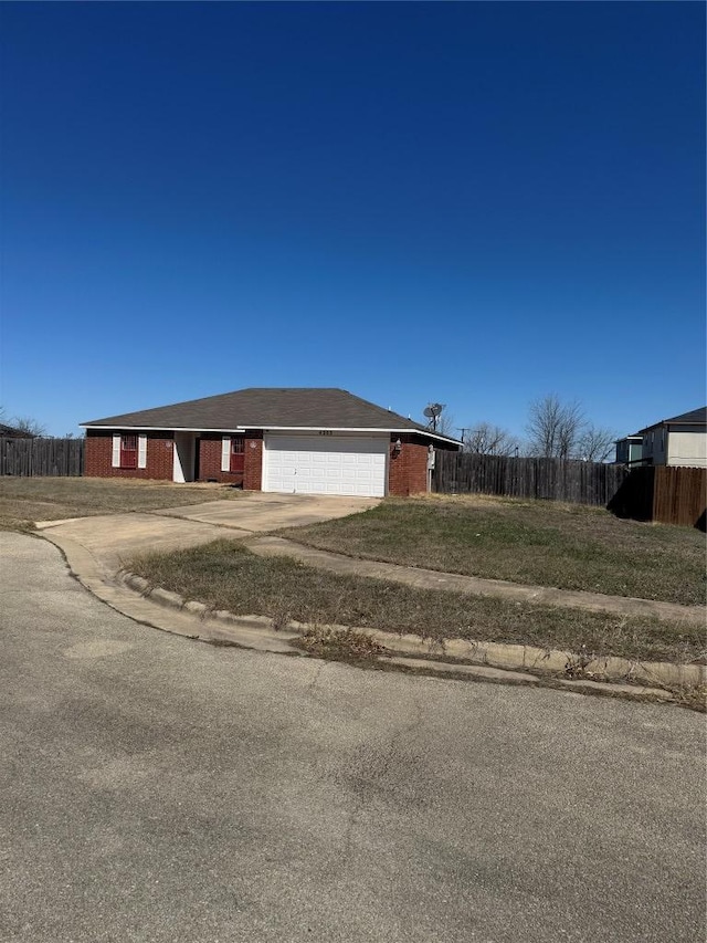 exterior space with brick siding, driveway, a garage, and fence