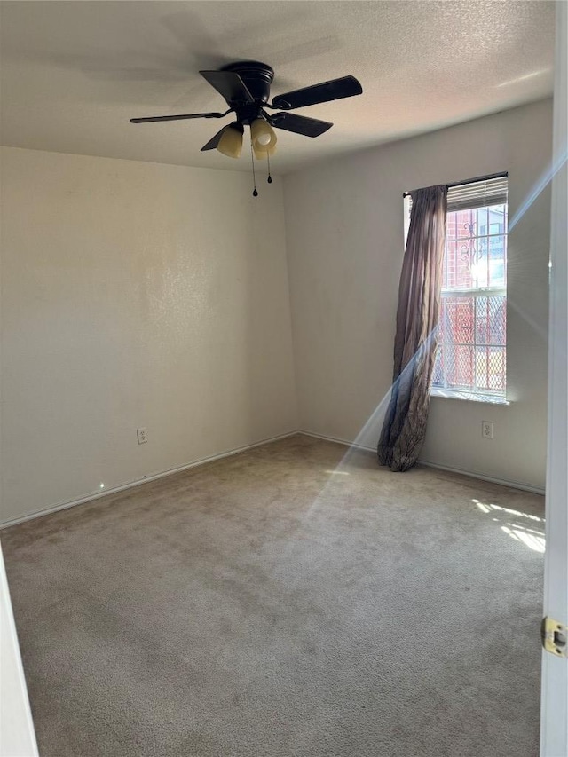 empty room with a ceiling fan, carpet, and a textured ceiling