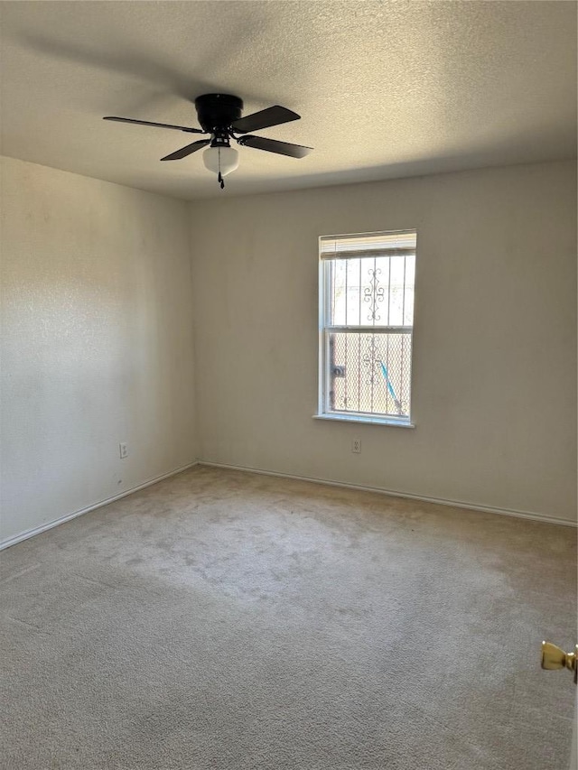 carpeted empty room with ceiling fan and a textured ceiling