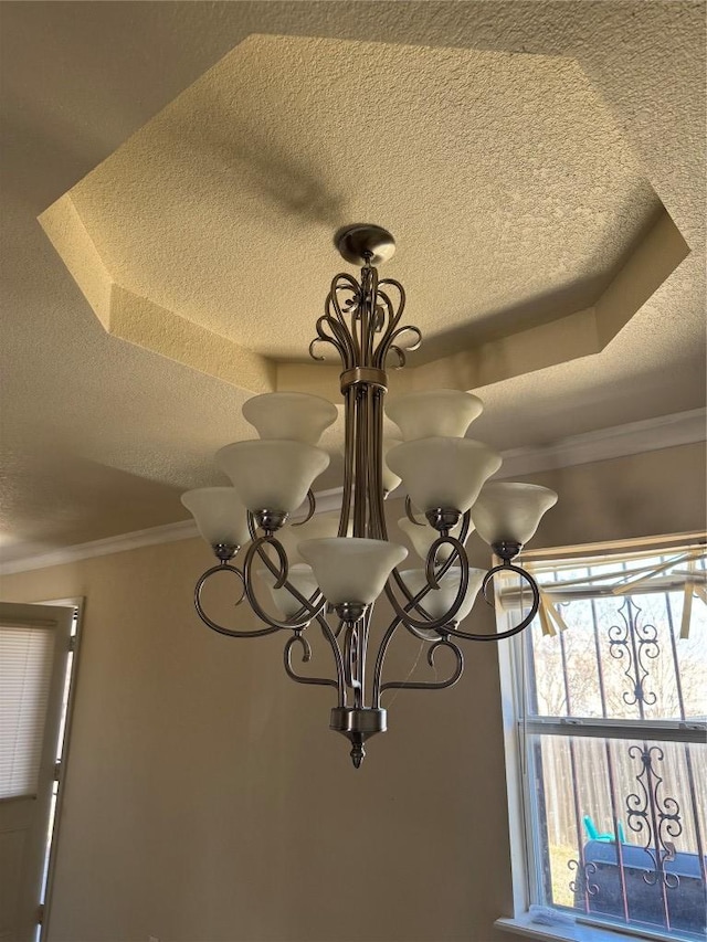 details with a textured ceiling, a chandelier, and ornamental molding