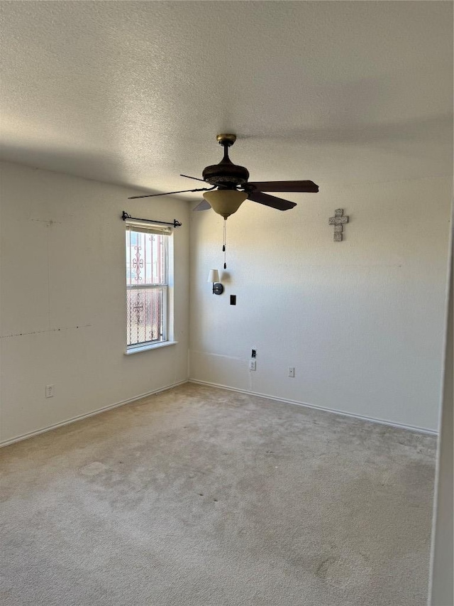 spare room featuring light carpet, a textured ceiling, and ceiling fan