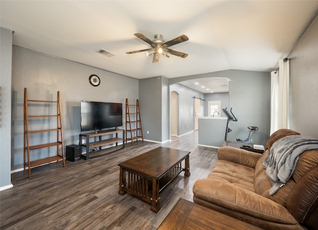 living room featuring visible vents, a ceiling fan, wood finished floors, arched walkways, and baseboards