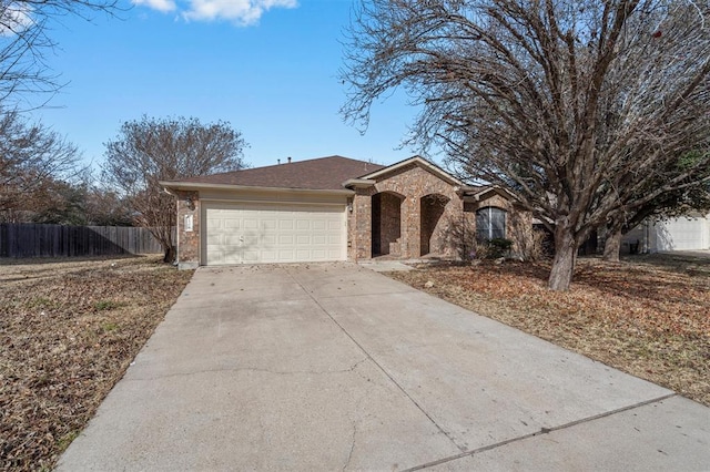 ranch-style house featuring brick siding, a shingled roof, fence, a garage, and driveway