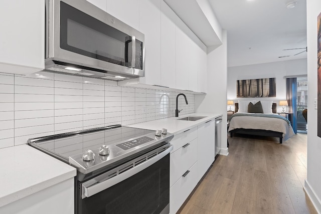 kitchen with white cabinets, stainless steel appliances, modern cabinets, and a sink