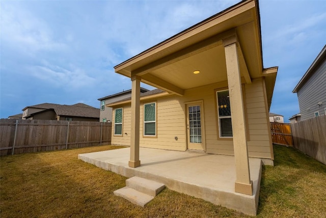 rear view of property with a patio area, a lawn, and a fenced backyard