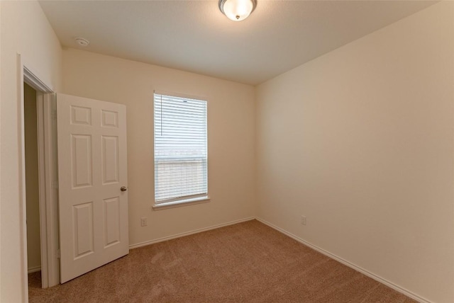 carpeted empty room with baseboards