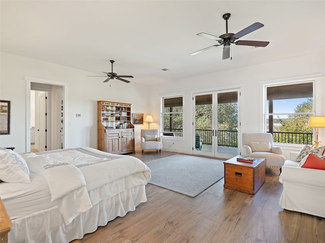 bedroom with multiple windows, wood finished floors, ceiling fan, and access to outside