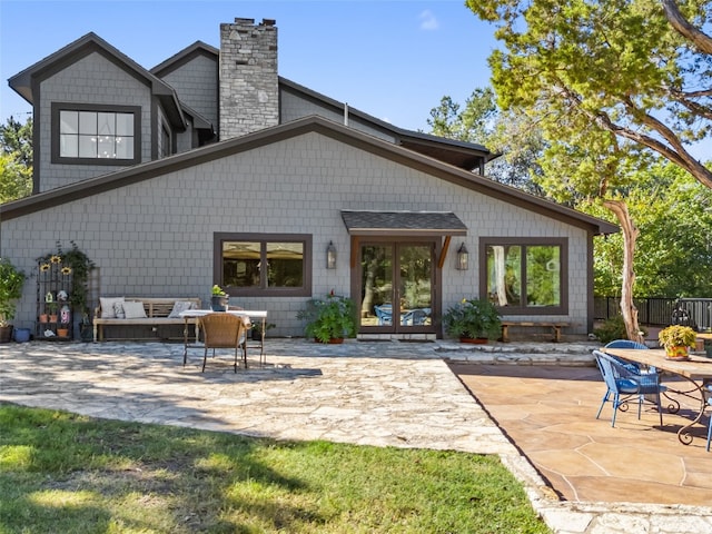 back of house featuring french doors, a patio, a chimney, and fence