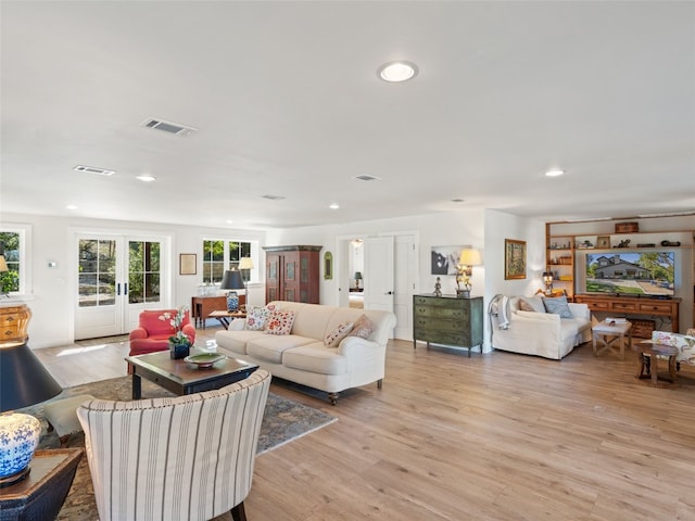 living room with visible vents, french doors, and light wood-type flooring