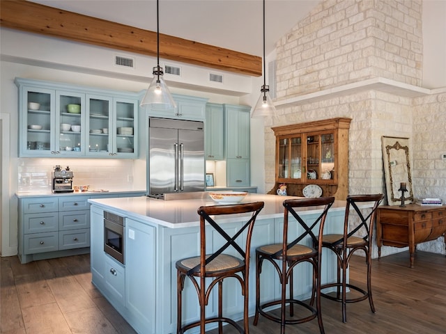 kitchen featuring built in appliances, light countertops, and dark wood-style flooring