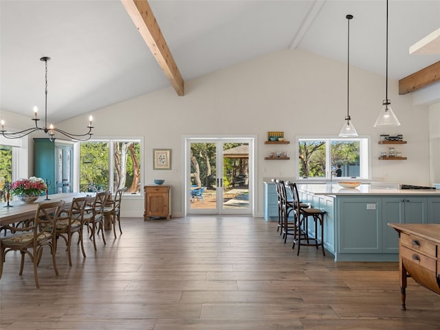 dining space with beam ceiling, plenty of natural light, and wood finished floors