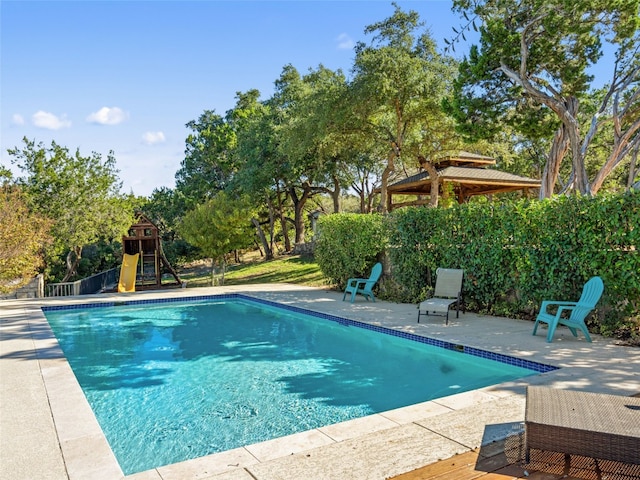 view of swimming pool with a patio area, a fenced in pool, and a playground