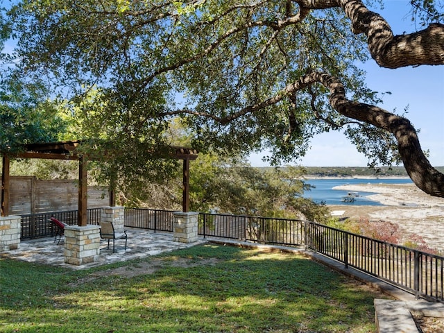 view of yard featuring a patio area, fence, and a water view