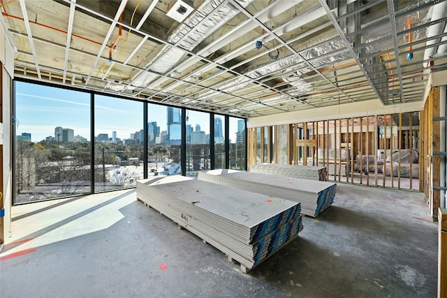 unfurnished bedroom with a view of city and concrete flooring