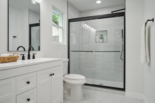 bathroom with baseboards, vanity, toilet, and a shower stall