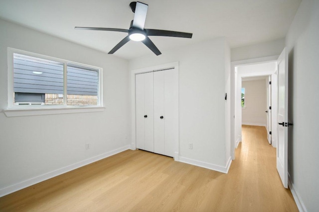 unfurnished bedroom featuring light wood-type flooring, baseboards, a closet, and ceiling fan