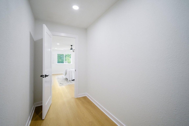 hallway with recessed lighting, baseboards, and light wood finished floors