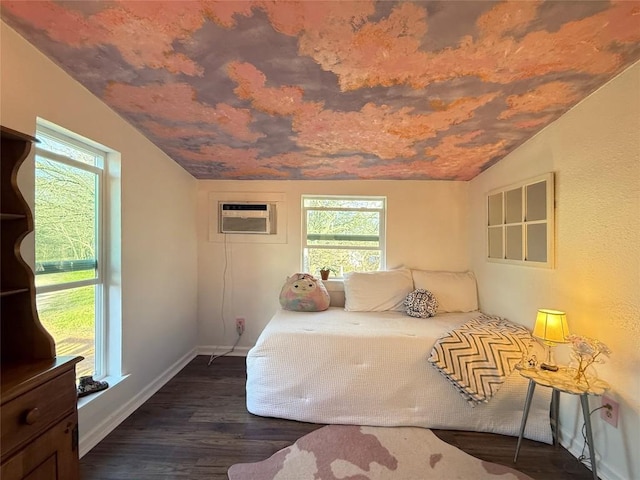 bedroom featuring dark wood-style floors, multiple windows, a wall mounted AC, and vaulted ceiling