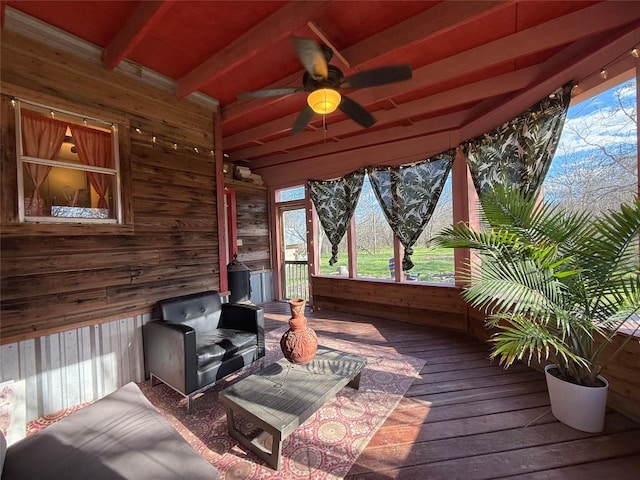 sunroom / solarium featuring beamed ceiling and a ceiling fan