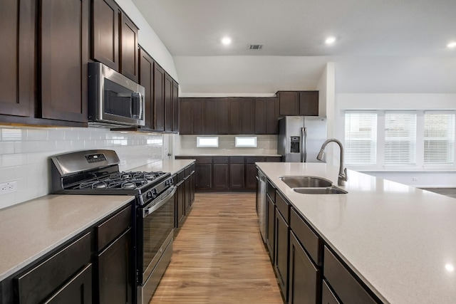 kitchen featuring dark brown cabinetry, visible vents, stainless steel appliances, and a sink