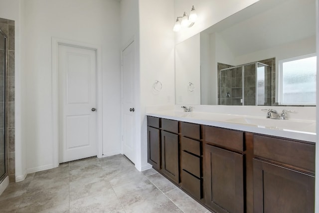 bathroom featuring double vanity, a stall shower, and a sink