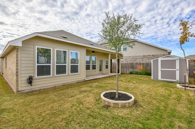 rear view of property featuring fence, a patio area, a lawn, a storage shed, and an outbuilding