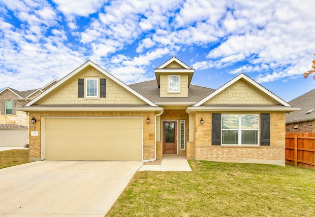 view of front facade featuring brick siding, fence, a front yard, a garage, and driveway