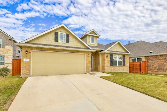 view of front of house with an attached garage, concrete driveway, a front yard, and fence