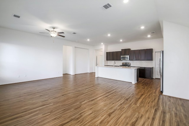 kitchen featuring stainless steel appliances, visible vents, open floor plan, and dark wood-style flooring