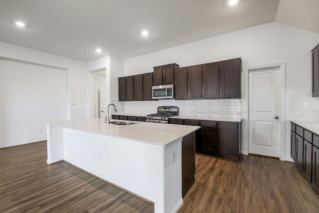 kitchen with dark wood finished floors, stainless steel appliances, lofted ceiling, and a sink