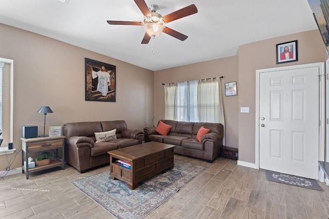 living room featuring ceiling fan, baseboards, and wood finish floors