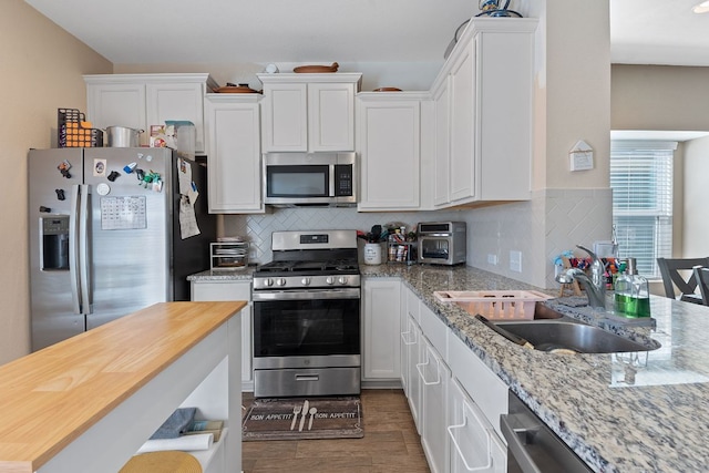 kitchen with a sink, appliances with stainless steel finishes, and white cabinetry