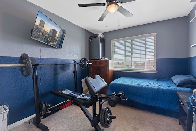 carpeted bedroom featuring a textured wall, baseboards, and ceiling fan