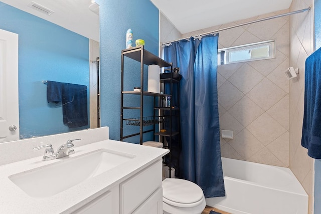 bathroom with vanity, visible vents, shower / bath combination with curtain, toilet, and a textured wall