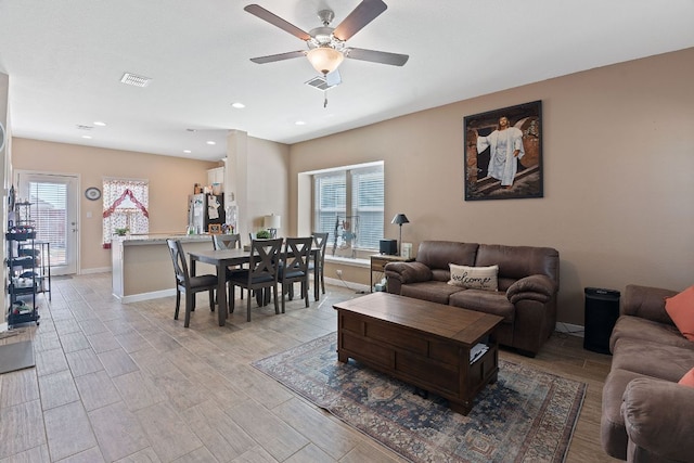 living room with light wood-style flooring, baseboards, and visible vents