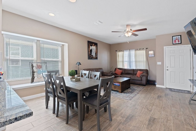 dining area with visible vents, baseboards, light wood-style floors, and ceiling fan