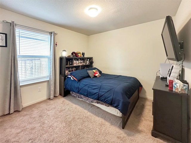 bedroom with baseboards, light colored carpet, and a textured ceiling