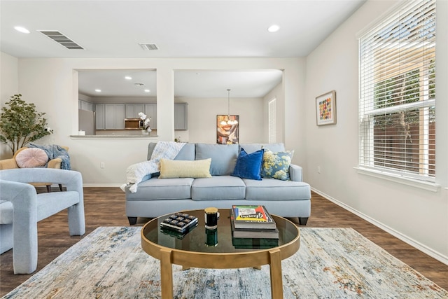 living room with dark wood-type flooring, baseboards, and visible vents