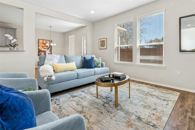 living room featuring a notable chandelier, recessed lighting, wood finished floors, and baseboards