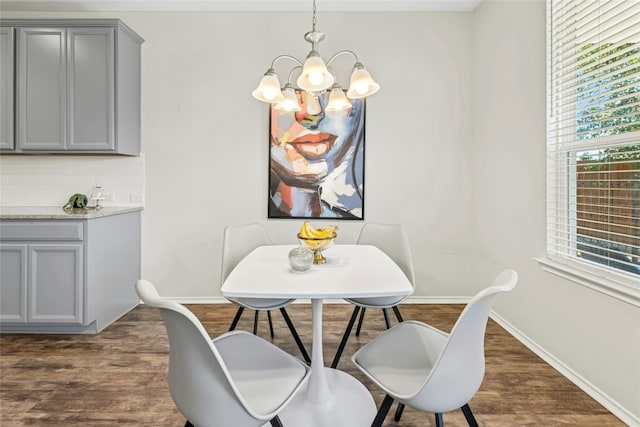 dining room featuring baseboards, an inviting chandelier, and dark wood finished floors