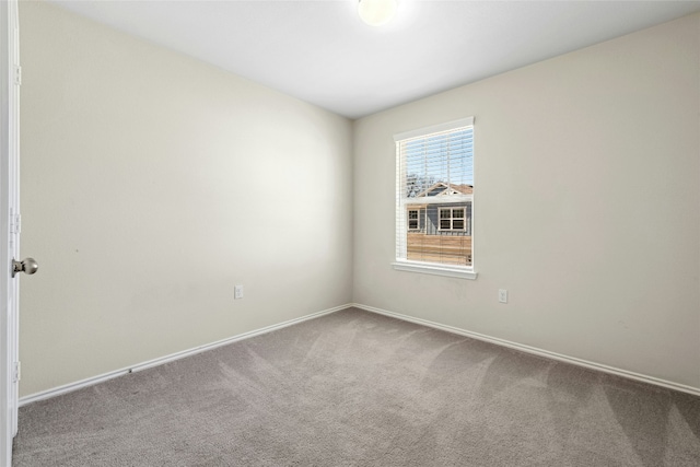 spare room featuring baseboards and carpet