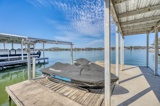 dock area with boat lift and a water view