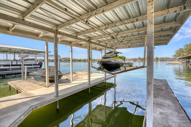 dock area featuring boat lift and a water view