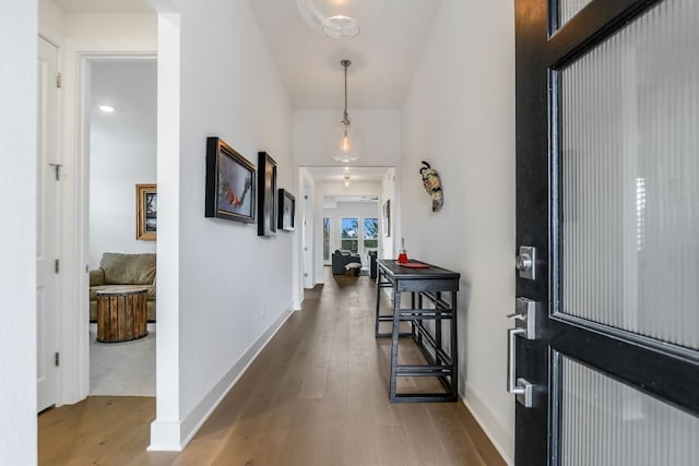 corridor featuring baseboards and wood finished floors