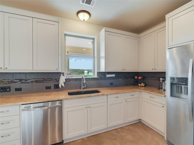 kitchen with visible vents, a sink, white cabinets, appliances with stainless steel finishes, and tasteful backsplash