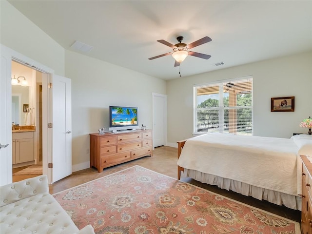 bedroom with a ceiling fan, baseboards, visible vents, and ensuite bathroom